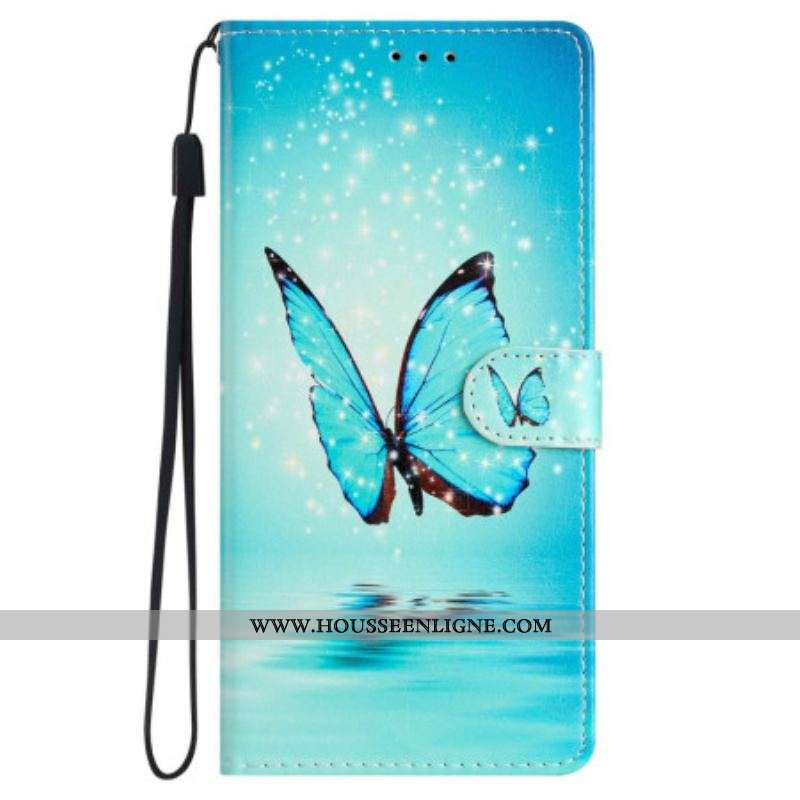 Housse iPhone 15 Papillon Bleu en Vol à Lanière